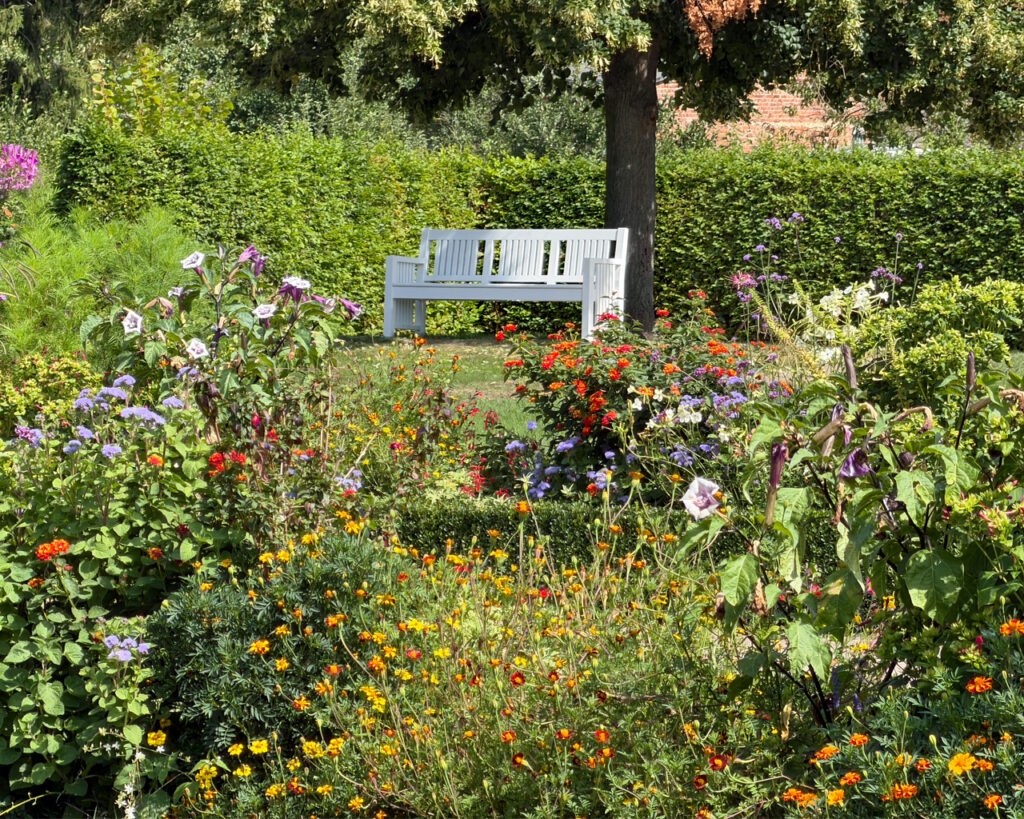 Idyllische Bank zwischen Blumen im Park